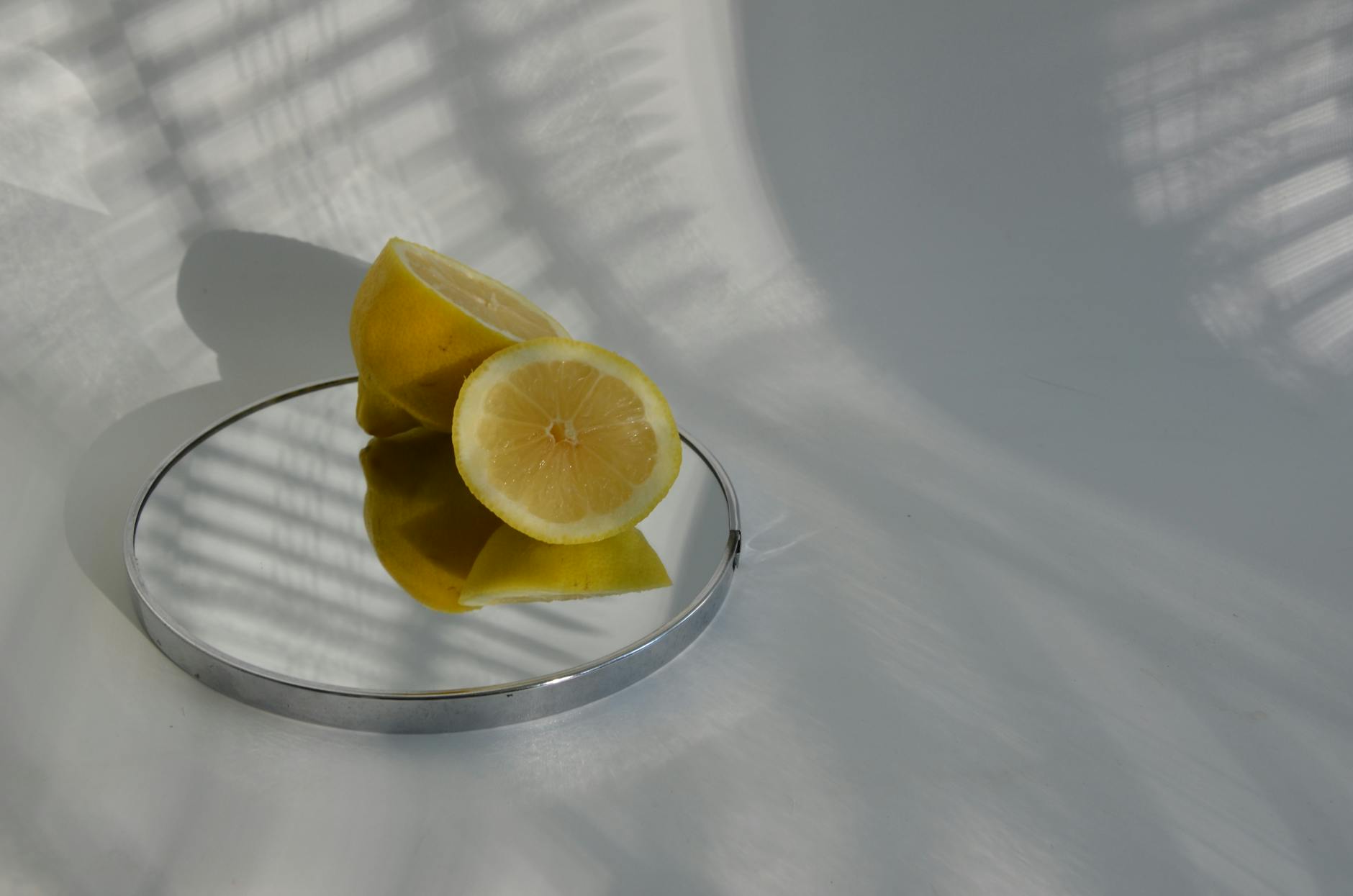 A teal clitoral vibrator resting on smooth white silk fabric